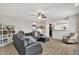 Spacious living room features a ceiling fan and an oversized sectional sofa with a decorative bookcase at 3740 Weather Stone Xing, Zionsville, IN 46077