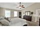 Well-lit main bedroom with high ceiling features a ceiling fan, carpet, and a large dresser with mirror at 3740 Weather Stone Xing, Zionsville, IN 46077