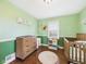 Charming Bedroom with changing table, wooden crib, and cheerful decor, perfect for a cozy start at 3809 N Glenwood Ave, Muncie, IN 47304