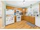 Bright kitchen with oak cabinets, white appliances, and a colorful array of decorations on the refrigerator at 3809 N Glenwood Ave, Muncie, IN 47304