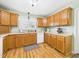 Well-lit kitchen showcasing ample oak cabinets, modern white appliances, and a view from the window at 3809 N Glenwood Ave, Muncie, IN 47304