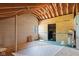 Unfinished attic space with exposed beams, unfinished walls, plywood flooring, and a single window at 396 W 500 S, Anderson, IN 46013