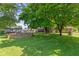 Lush backyard with a brick-lined feature and mature trees offering shade, creating a serene outdoor space at 396 W 500 S, Anderson, IN 46013