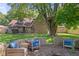 Private backyard with a brick firepit, mature trees and patio seating at 396 W 500 S, Anderson, IN 46013