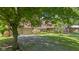 Front exterior of home with a brick facade, mature trees, and a paved driveway leading to an attached two-car garage at 396 W 500 S, Anderson, IN 46013