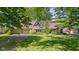Charming front exterior view of home with brick facade, mature trees, and a well-manicured lawn at 396 W 500 S, Anderson, IN 46013