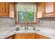 Kitchen sink area featuring a dual basin stainless sink, granite countertops and decorative backsplash at 396 W 500 S, Anderson, IN 46013