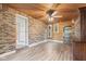 Sunny sunroom with wood paneled ceiling, brick accent wall, wood floors and bright lighting at 396 W 500 S, Anderson, IN 46013