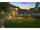 Inviting backyard with a charming patio area and lush green lawn at twilight at 4046 N Park Ave, Indianapolis, IN 46205