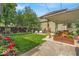 Green backyard with a covered patio, beautiful landscaping, and mature trees at 4046 N Park Ave, Indianapolis, IN 46205