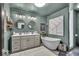 This bathroom showcases a double vanity, soaking tub, and soothing green walls for a spa-like experience at 4046 N Park Ave, Indianapolis, IN 46205