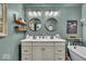 This bathroom showcases a double vanity, soaking tub, and soothing green walls for a spa-like experience at 4046 N Park Ave, Indianapolis, IN 46205