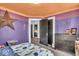 This bedroom boasts playful purple walls, bright accents, and a door leading to another room at 4046 N Park Ave, Indianapolis, IN 46205