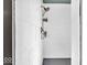 This shower features white subway tiles, bronze fixtures, and convenient built-in shelving for toiletries at 4046 N Park Ave, Indianapolis, IN 46205