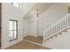 Bright entryway featuring wood floors, a staircase, and access to storage and the front door at 4291 Caledonia Way, Indianapolis, IN 46254