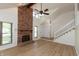 Open living room with a brick fireplace, new floors, and large windows providing ample light at 4291 Caledonia Way, Indianapolis, IN 46254