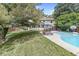 Spacious backyard with a refreshing pool, lounge chairs, an outdoor dining area, and mature trees, creating a private oasis at 4431 Cranbrook Dr, Indianapolis, IN 46250