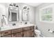 Bathroom vanity with double sinks, wood cabinets, and modern lighting at 4431 Cranbrook Dr, Indianapolis, IN 46250
