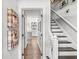 Bright hallway showcasing hardwood floors leading to the kitchen and an adjacent staircase at 4431 Cranbrook Dr, Indianapolis, IN 46250