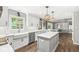 Well-lit kitchen with white cabinets, quartz countertops, stainless steel appliances, and a functional island at 4431 Cranbrook Dr, Indianapolis, IN 46250