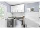 Modern laundry room featuring stainless steel washer and dryer, ample storage, and clean, bright finishes at 4431 Cranbrook Dr, Indianapolis, IN 46250
