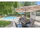 Outdoor pool area features a dining table and patio under a large umbrella, perfect for entertaining and relaxing in the backyard at 4431 Cranbrook Dr, Indianapolis, IN 46250