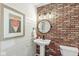 Stylish half-bathroom with brick accent wall, pedestal sink, and modern fixtures at 4431 Cranbrook Dr, Indianapolis, IN 46250
