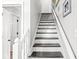 A clean staircase with a white banister leads upstairs with entryways on both sides at 4431 Cranbrook Dr, Indianapolis, IN 46250