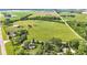 Expansive farmland with a charming home nestled among mature trees and a road nearby at 4535 N Us Hwy 52, Thorntown, IN 46071