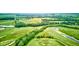 An aerial view showcasing the verdant golf course, highlighted by a pond and lush tree line at 4535 N Us Hwy 52, Thorntown, IN 46071