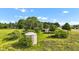 An aerial view shows the house, silo, and trees on this sprawling piece of land at 4535 N Us Hwy 52, Thorntown, IN 46071