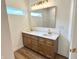 Bright bathroom featuring a double sink vanity with a framed mirror and gold fixtures at 4726 Deacon Ln, Indianapolis, IN 46237