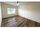 Light-filled bedroom features wood-look vinyl flooring, a ceiling fan, and a large window at 4726 Deacon Ln, Indianapolis, IN 46237