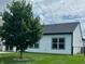 Back of home with a manicured lawn, mature tree, and visible windows at 4726 Deacon Ln, Indianapolis, IN 46237