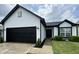 Charming home featuring a black garage door, white siding, and a well-manicured lawn at 4726 Deacon Ln, Indianapolis, IN 46237