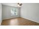 Bright bedroom features hardwood floors, ceiling fan, and a window letting in natural light at 5003 Opal Ridge Ln # 101, Indianapolis, IN 46237