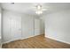 Bright bedroom features hardwood floors, a ceiling fan, and multiple doorways for easy access at 5003 Opal Ridge Ln # 101, Indianapolis, IN 46237