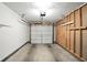 A well-lit garage featuring exposed framing, shelves, and a new garage door, suitable for parking and storage at 5003 Opal Ridge Ln # 101, Indianapolis, IN 46237