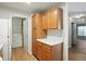 Kitchen leading into a laundry area featuring wood cabinets and white appliances at 5003 Opal Ridge Ln # 101, Indianapolis, IN 46237