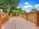 An empty wooden deck, offers a clean slate for outdoor entertaining with a beautiful backyard view surrounded by trees at 528 W Mechanic St, Shelbyville, IN 46176