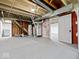 Open basement space with exposed ductwork, utility area, and red brick painted accent wall at 528 W Mechanic St, Shelbyville, IN 46176