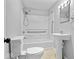 Bright bathroom with a shower/tub combo, accessible grab bars, and a pedestal sink, designed for safety and convenience at 528 W Mechanic St, Shelbyville, IN 46176