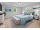 Comfortable main bedroom with a plush blue bed, elegant decor, and ample natural light from the surrounding windows at 528 W Mechanic St, Shelbyville, IN 46176