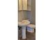 This bathroom includes a pedestal sink and a toilet, along with wall storage at 5344 Fletcher Ave, Indianapolis, IN 46219
