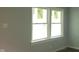 Empty bedroom with light-blue walls and new windows with papers on them at 5344 Fletcher Ave, Indianapolis, IN 46219