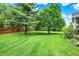 Large backyard featuring a well-manicured lawn, mature trees, and a partial fence, creating a private outdoor space for relaxation and recreation at 58 Penn Pl, Zionsville, IN 46077