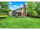 Lush backyard featuring a screened-in porch, well-maintained lawn, mature trees, and partial fence to offer privacy and outdoor enjoyment at 58 Penn Pl, Zionsville, IN 46077