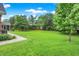 Expansive backyard features a large lawn, mature trees, and partial fence, providing a serene and private outdoor space for recreation at 58 Penn Pl, Zionsville, IN 46077