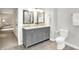 Bathroom featuring a double vanity with grey cabinets, marble countertop, and grey tile floors at 58 Penn Pl, Zionsville, IN 46077