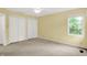 Bedroom with yellow walls and carpet with large closet doors and a window at 58 Penn Pl, Zionsville, IN 46077
